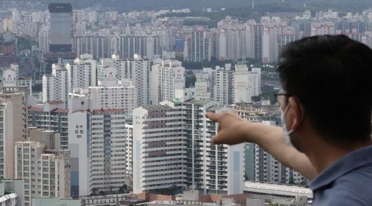 한 시민이 서울 노원구 일대 아파트 밀집 지역을 가리키고 있다. <연합뉴스>